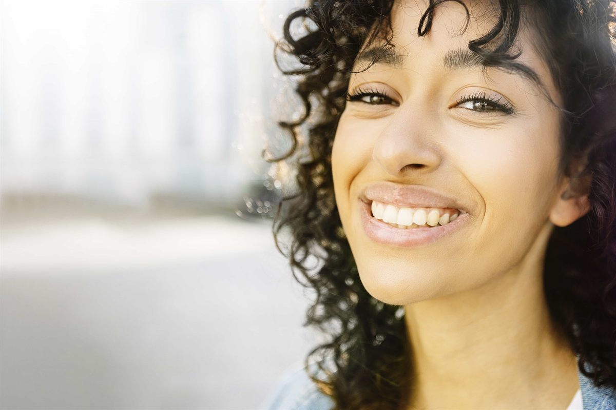 A woman laughing, showing bright healthy teeth